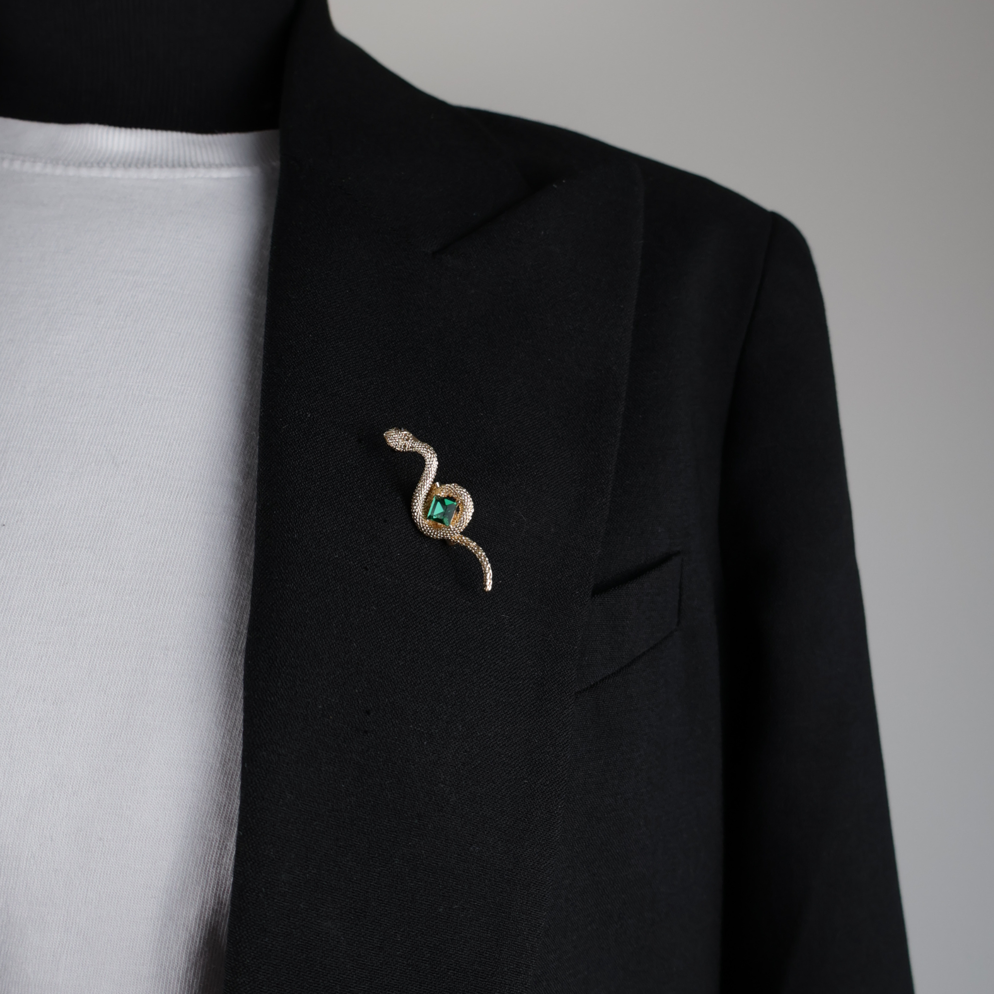 10023 brooch pin gold snake with green bead on black blazer