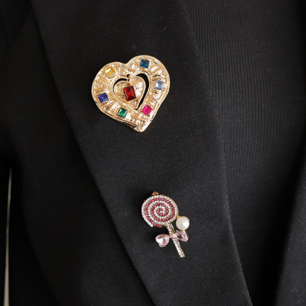 zwarte blazer broche goud hart met gekleurde steentjes en roze lollipop