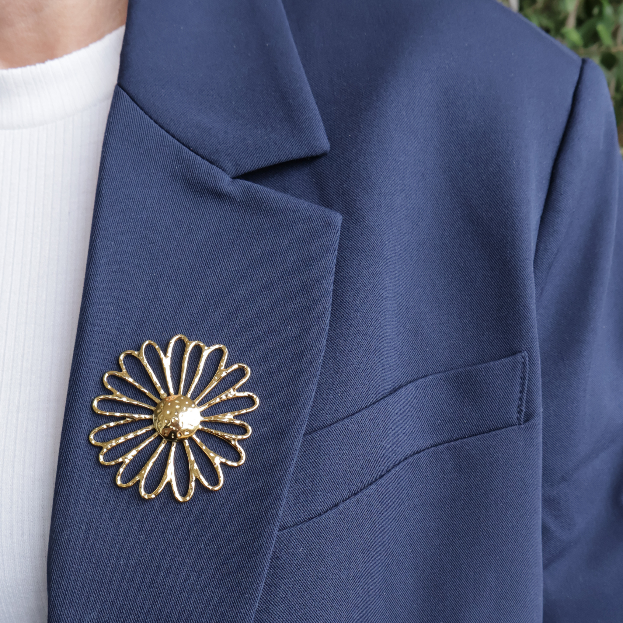 Pin goud open bloem op blauwe blazer