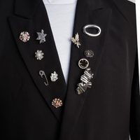Broches en pins op zwarte blazer