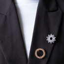 Zwarte blazer met zilveren broche rond zonnestralen en roze steentje ronde broche