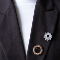 Zwarte blazer met zilveren broche rond zonnestralen en roze steentje ronde broche