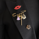 broches lipjes rood, goud safety pin en in goud zwart op zwarte blazer