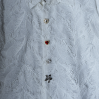 Button covers gold, silver, red on white blouse