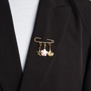 sierspeld goud met zeester schelp en roze bloem op zwarte blazer